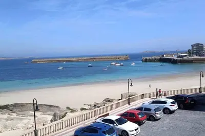 a group of cars parked next to a beach at Casa do Cervo - San Cibrao in San Ciprián
