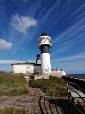 a lighthouse sitting on top of a hill near the ocean at Casa do Cervo - San Cibrao in San Ciprián