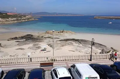 a group of cars parked next to a beach at Casa do Cervo - San Cibrao in San Ciprián