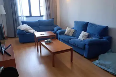a living room with a blue couch and a coffee table at Casa do Cervo - San Cibrao in San Ciprián