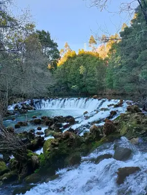 a river with snow on the rocks and trees at Casa da Rapadoira in Laxoso de Abaixo