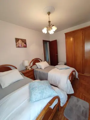 a bedroom with two beds and a chandelier at Casa da Rapadoira in Laxoso de Abaixo