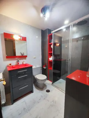 a bathroom with a toilet and a glass shower at Piso Pauser in Puentecesures