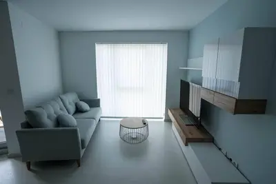 a living room with a blue couch and a window at Apartamento con TERRAZA en Burela in Burela de Cabo