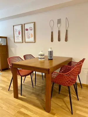 a wooden table with chairs and utensils on a wall at Andainas C in Milladoiro