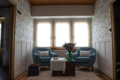 a living room with two blue chairs and a table at Casa Arturo in Tríacastela