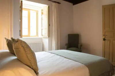a bedroom with a large white bed with a window at Casa Arturo in Tríacastela