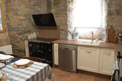 a kitchen with a sink and a stove and a table at Casa Arturo in Tríacastela