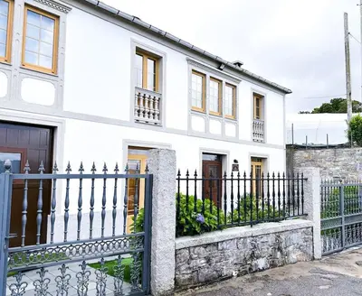 a white house with a black fence at Casa Arturo in Tríacastela