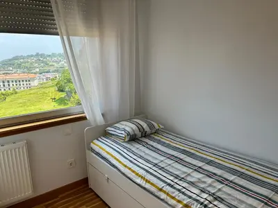 a bed with a pillow in a room with a window at Playa Miño in Miño