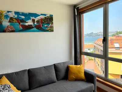 a living room with a couch and a large window at Playa Miño in Miño
