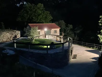 a house at night with a stone wall at Da man da Moura in Ourense