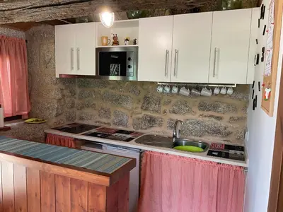 a kitchen with white cabinets and a sink at Da man da Moura in Ourense