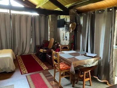 a room with a table and chairs and a bed at Da man da Moura in Ourense