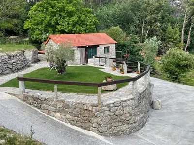 a stone retaining wall in front of a house at Da man da Moura in Ourense