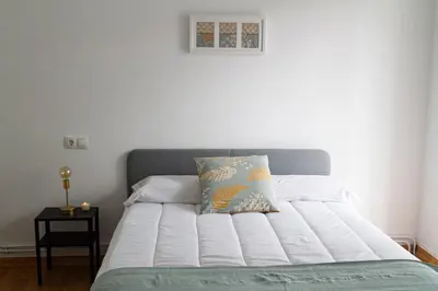 a white bed with a pillow on top of it at Muralla de Tata in Lugo