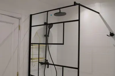 a glass shower door with a light on the wall at Muralla de Tata in Lugo