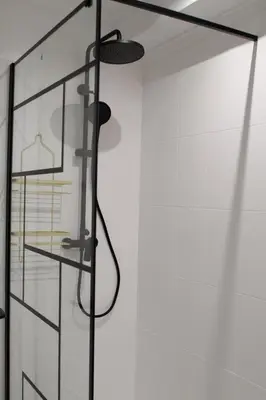 a shower with a glass door with a rack at Muralla de Tata in Lugo
