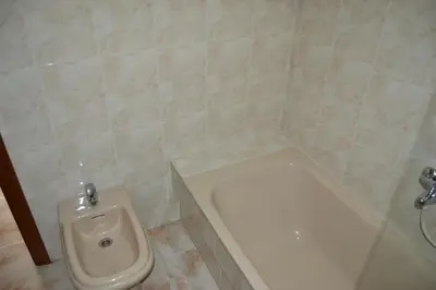 a bathroom with a toilet and a urinal and a bidet at Inmoinsuas Plaza de Galicia 32 in Sarria