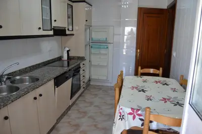 a small kitchen with a table and a sink at Inmoinsuas Plaza de Galicia 32 in Sarria