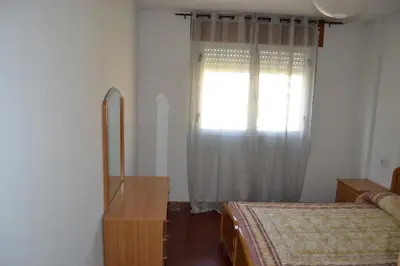 a bedroom with a window and a bed and a dresser at Inmoinsuas Plaza de Galicia 32 in Sarria