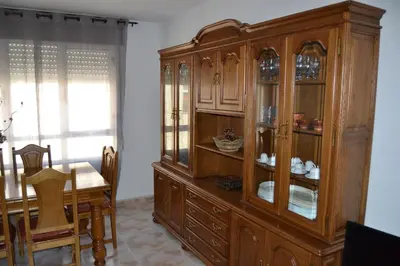 a large wooden cabinet in a dining room with a table at Inmoinsuas Plaza de Galicia 32 in Sarria