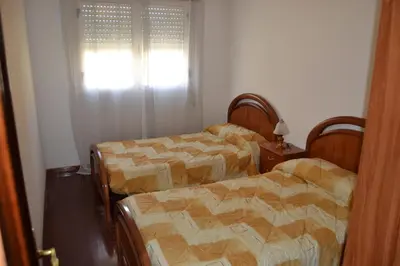 a room with two beds and a window with at Inmoinsuas Plaza de Galicia 32 in Sarria