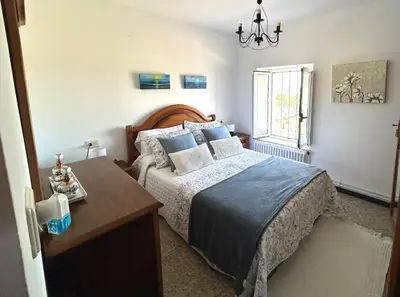 a bedroom with a bed and a table and a window at Casa Pancha in Ribadeo