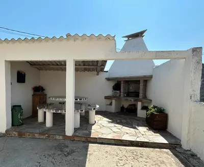 an outdoor patio with a table and a fireplace at Casa Pancha in Ribadeo