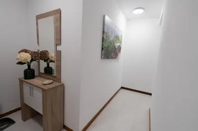 a hallway with a mirror and a table with flowers at Pension O Camiño Milladoiro in Amés