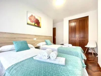 a hotel room with two beds with towels on them at Pension O Camiño Milladoiro in Amés