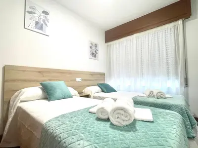 a bedroom with two beds with towels on them at Pension O Camiño Milladoiro in Amés