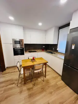 a kitchen with a wooden table with chairs and a refrigerator at A CASA DO LUGAR in Sampaio