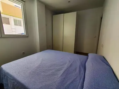 a small bedroom with a bed and a window at BAHíA APARTAMENTOS TURÍSTICOS in Foz