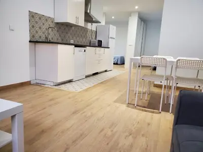 a kitchen with white cabinets and a table and chairs at BAHíA APARTAMENTOS TURÍSTICOS in Foz