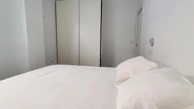 a white bed with white sheets in a bedroom at BAHíA APARTAMENTOS TURÍSTICOS in Foz