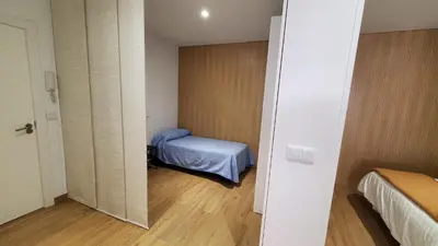 a small room with a bed and a mirror at BAHíA APARTAMENTOS TURÍSTICOS in Foz