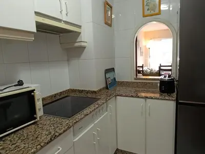 a kitchen with white cabinets and a sink and a mirror at Marusia in Viveiro