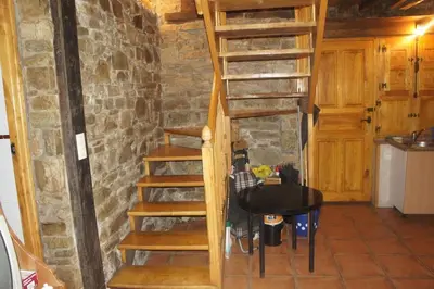 a wooden staircase in a room with a table at Casa Rural de montaña en LUARCA ASTURIAS in Busindre
