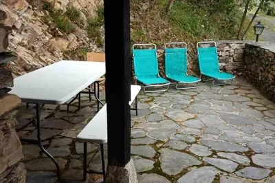 a group of blue chairs and a table and a table and chairs at Casa Rural de montaña en LUARCA ASTURIAS in Busindre