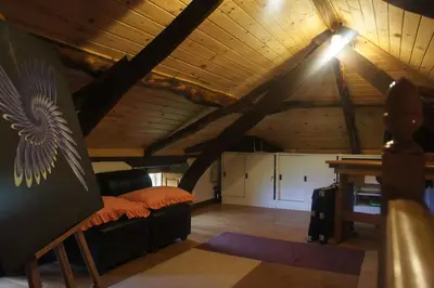 a attic room with a bed and a table in it at Casa Rural de montaña en LUARCA ASTURIAS in Busindre