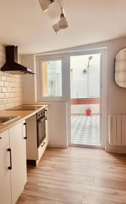 a kitchen with white cabinets and a large window at Casita típica de pescadores -Casa Gloria- WIFI in Burela de Cabo