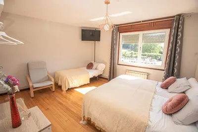 a bedroom with two beds and a window at Pensión Lobre in O Pedrouzo