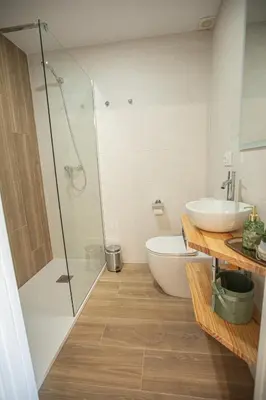 a bathroom with a shower and a toilet and a sink at Pensión Lobre in O Pedrouzo