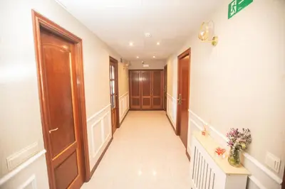 a hallway with wooden doors and flowers in a room at Pensión Lobre in O Pedrouzo