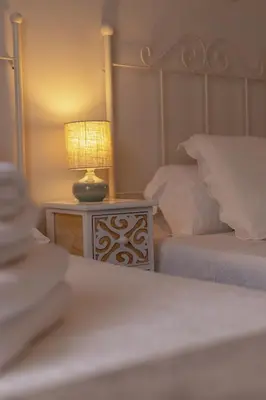 a bedroom with two beds and a lamp on a table at Pensión O Camiño in Sarria