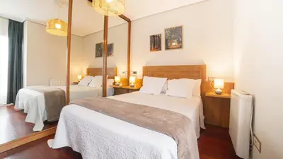 a bedroom with two beds and a mirror at Pensión O Camiño in Sarria