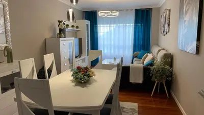 a dining room with a table and chairs and a living room at Casa da Alfóndega in Caldas de Reis
