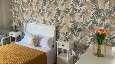a bedroom with a bed and a floral wallpaper at Casa da Alfóndega in Caldas de Reis