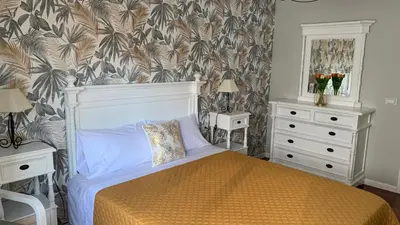 a bedroom with a bed and two night stands and two tables at Casa da Alfóndega in Caldas de Reis